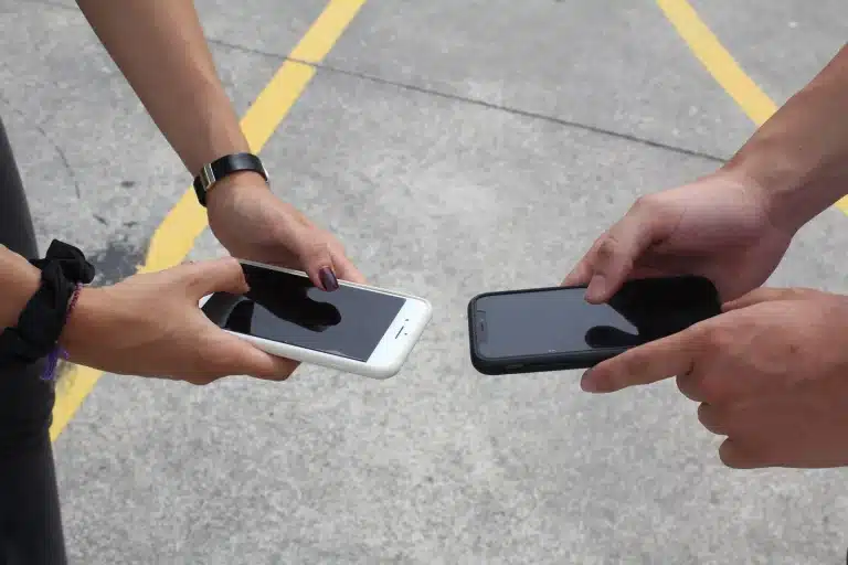 Two people holding smartphones side by side while transferring an eSIM to a new phone